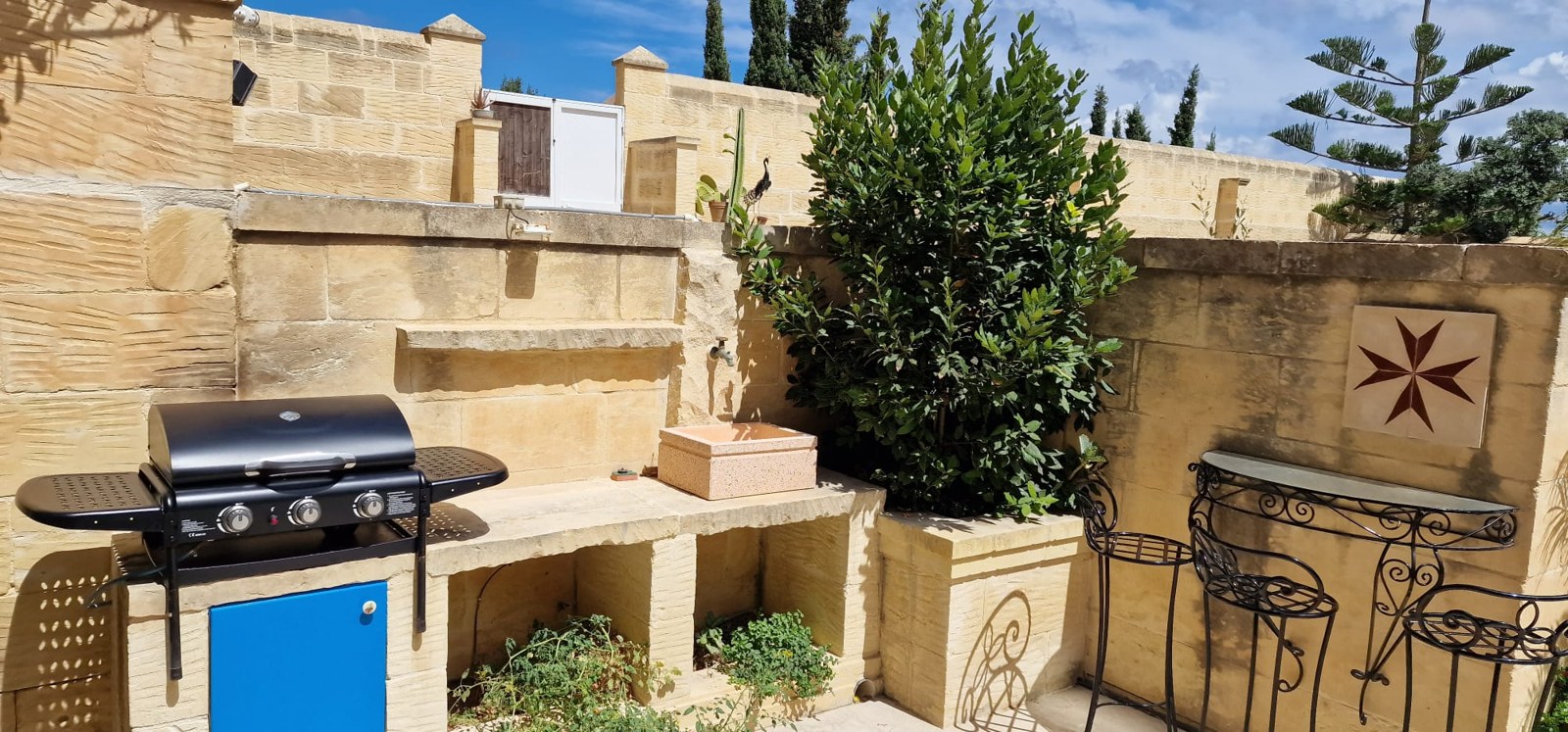 Outdoor barbecue and seating area at Molendini Farmhouse